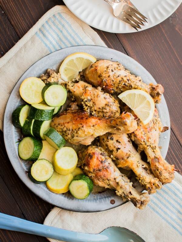 greek chicken thighs on a pie tin with squash.