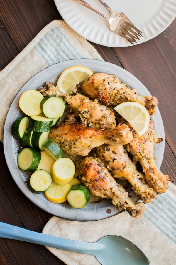 greek chicken thighs on a pie tin with squash.