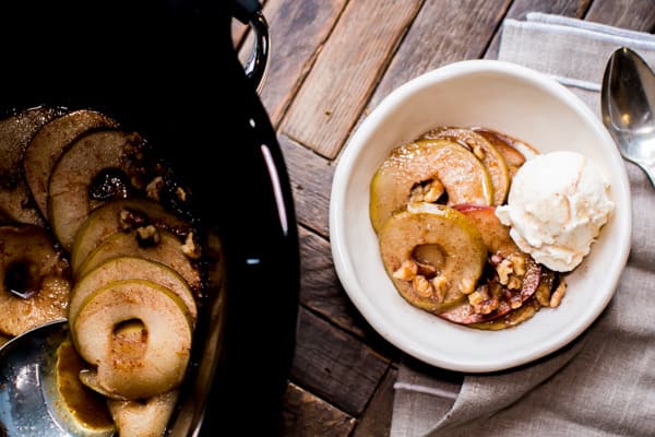 bowl of cooked apples sliced with ice cream on top.