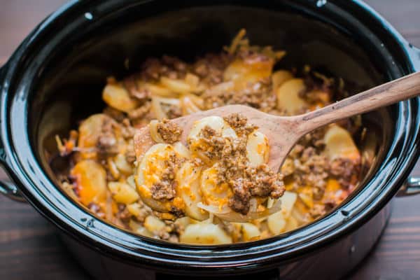 Beef and Potatoe Au Gratin in crockpot on spatula.