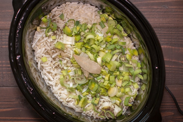 frozen hashbrowns, leeks and bay leaves in a slow cooker.