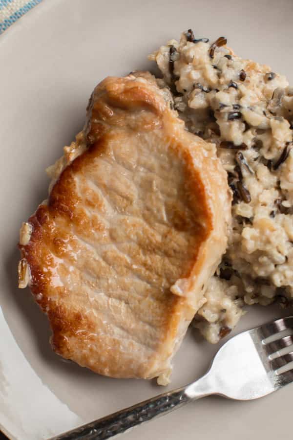 pork chop and wild rice mix on a plate.