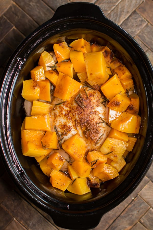 whole chicken done cooking in slow cooker with butternut squash.