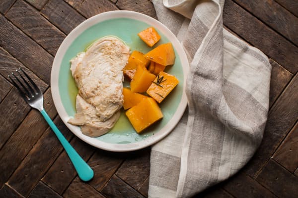 sliced chicken on a plate with butternut squash cubes.