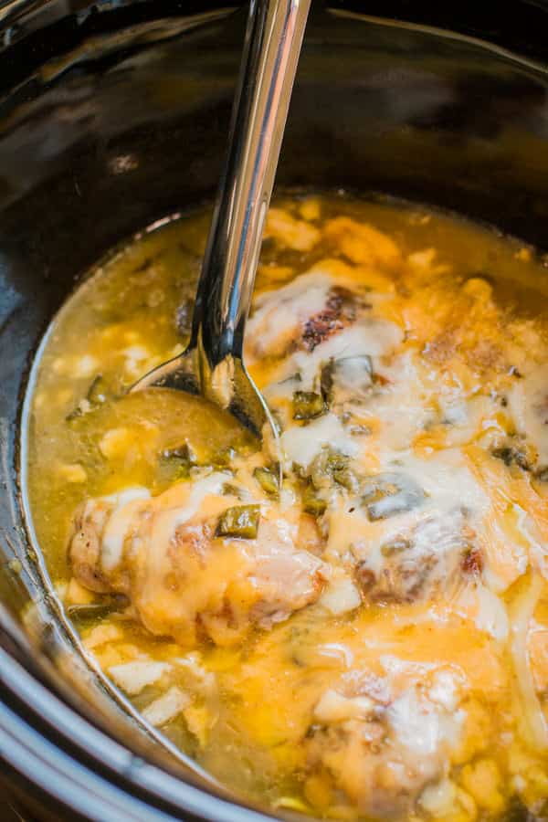 saucy green chile chicken thighs in a slow cooker