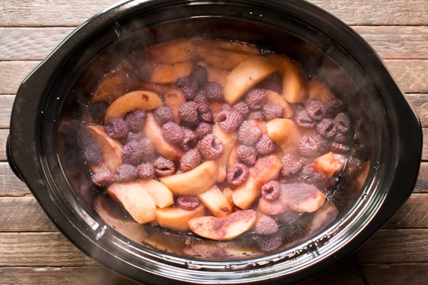 cooked apples and raspberries in a slow cooker