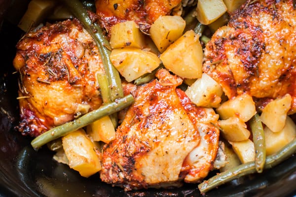 close up of chicken thighs in a slow cooker.
