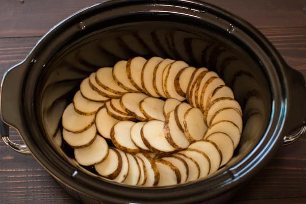 raw sliced potatoes in a slow cookerr.