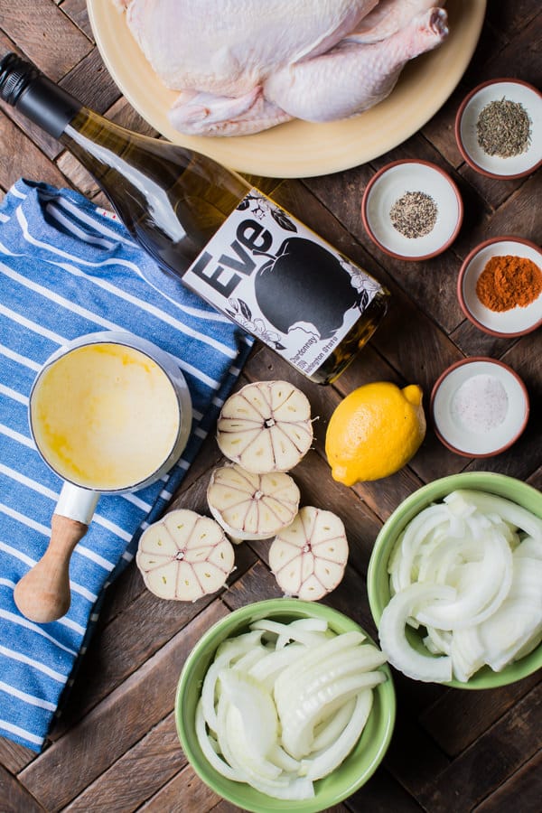 wine, seasonings, butter, onion garlic and lemon on a wooden table.