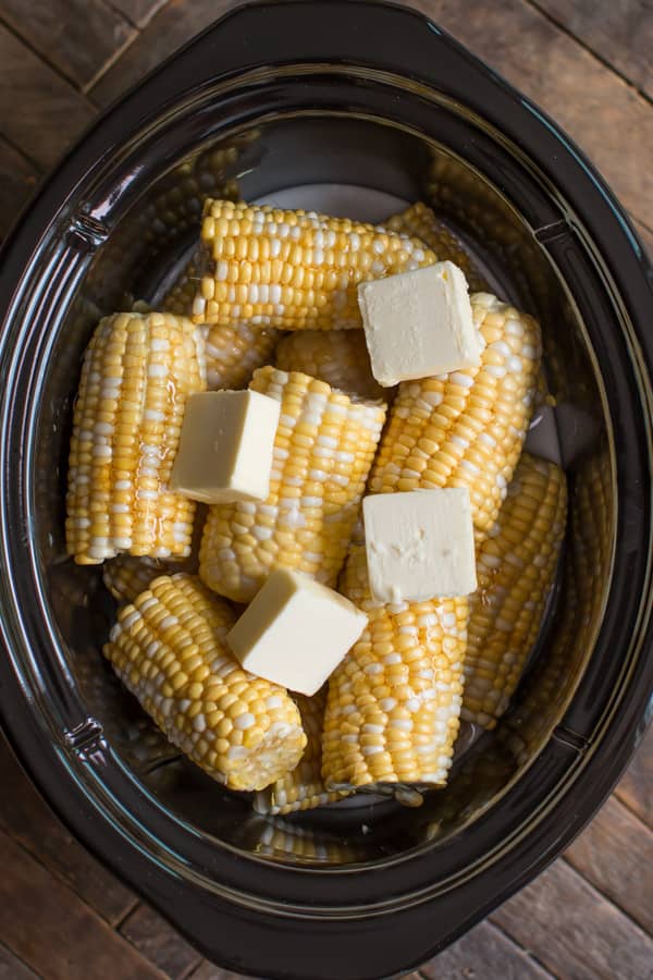 corn on the cob in a slow cooker with butter, honey and coconut milk.