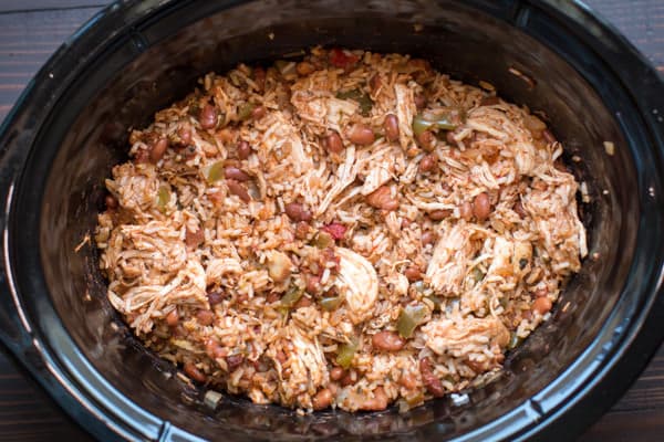 close up of rice, beans, peppers, and shredded chicken in a slow cooker