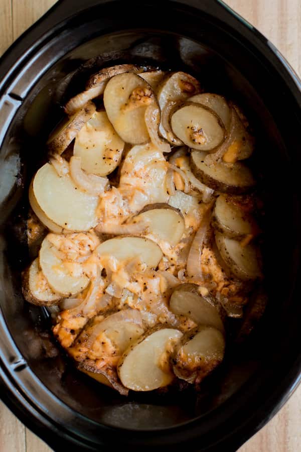 sliced potatoes, onions and russet potates in a slow cooker