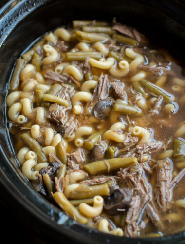 close up photo of french dip soup in a slow cooker.