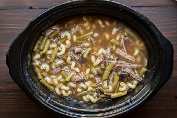 cavatappi pasta in a beef soup in slow cooker