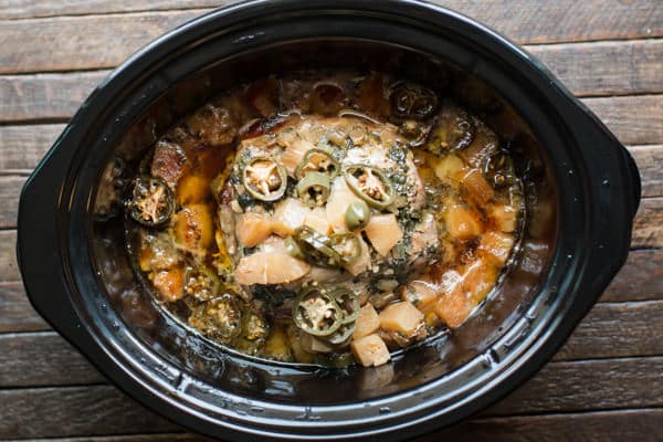 cooked pork roast with pineapple and jalapeno in a slow cooker.