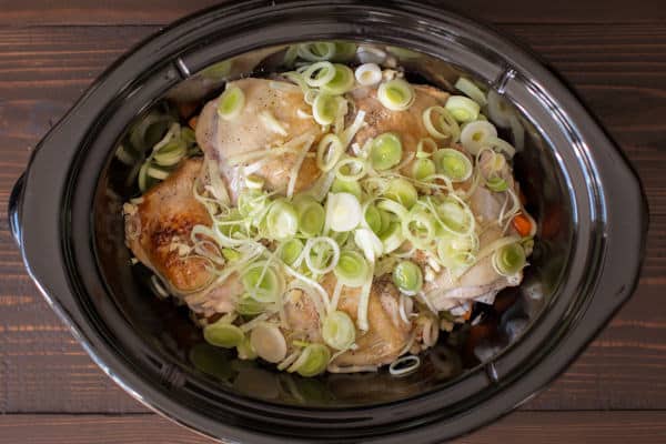 chicken thighs with raw leeks on the top.