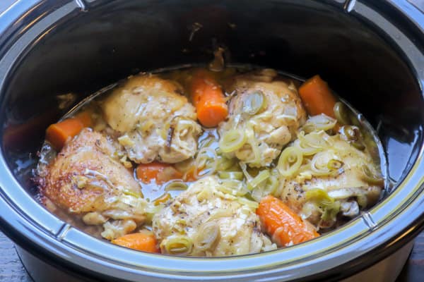 close up of chicken and leeks in a slow cooker