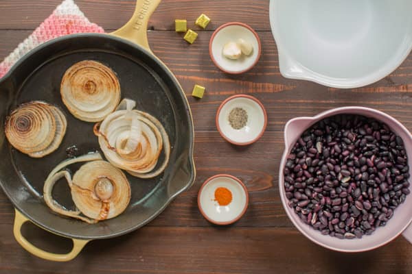 grilled onion slices, seasonings, soaked black beans, garlic and chicken bouillon cubes.