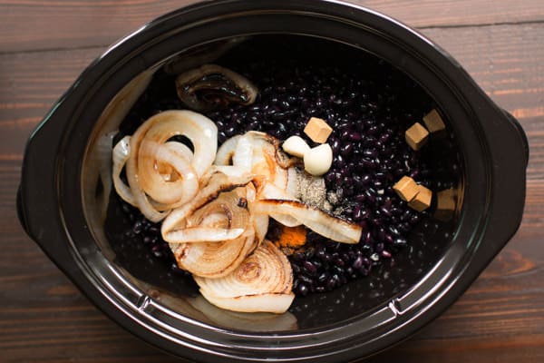 blacke beans, onion, garlic and chicken bouillon cubes in a slow cooker.