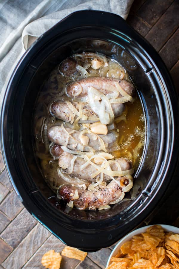 cooked brats in a slow cooker in a buttery sauce.