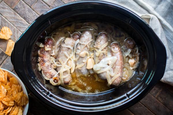 brats, garlic and onion in a slow cooker with chips on the side