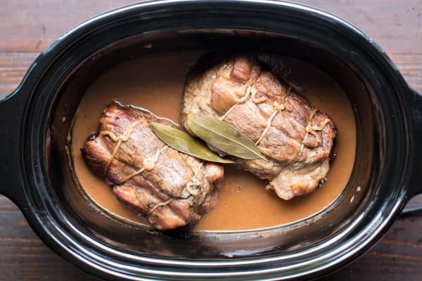 cooked pork roasts in a slow cooker with gravy