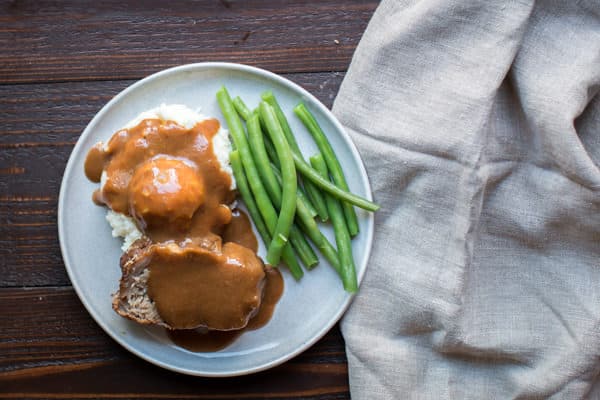 slices of pork roast on a plate with gravy