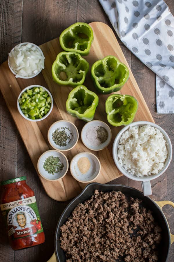 green bell peppers, onion, rice, seasonings, ground beef, marinara sauce on a table.