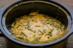 close up of cheesy green beans in a slow cooker