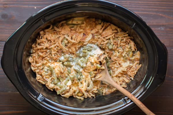 wooden spoon in cheesy green bean casserole, al ldone cooking.