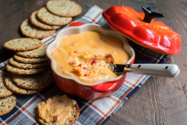 horseradish velveeta dip in a red bowl served with crackers