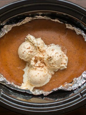 slow cooker lined with foil. Pumpkin pie with ice cream on top in it.