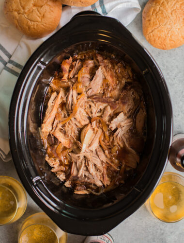 shredded pork in the slow cooker with buns and cider on the side.