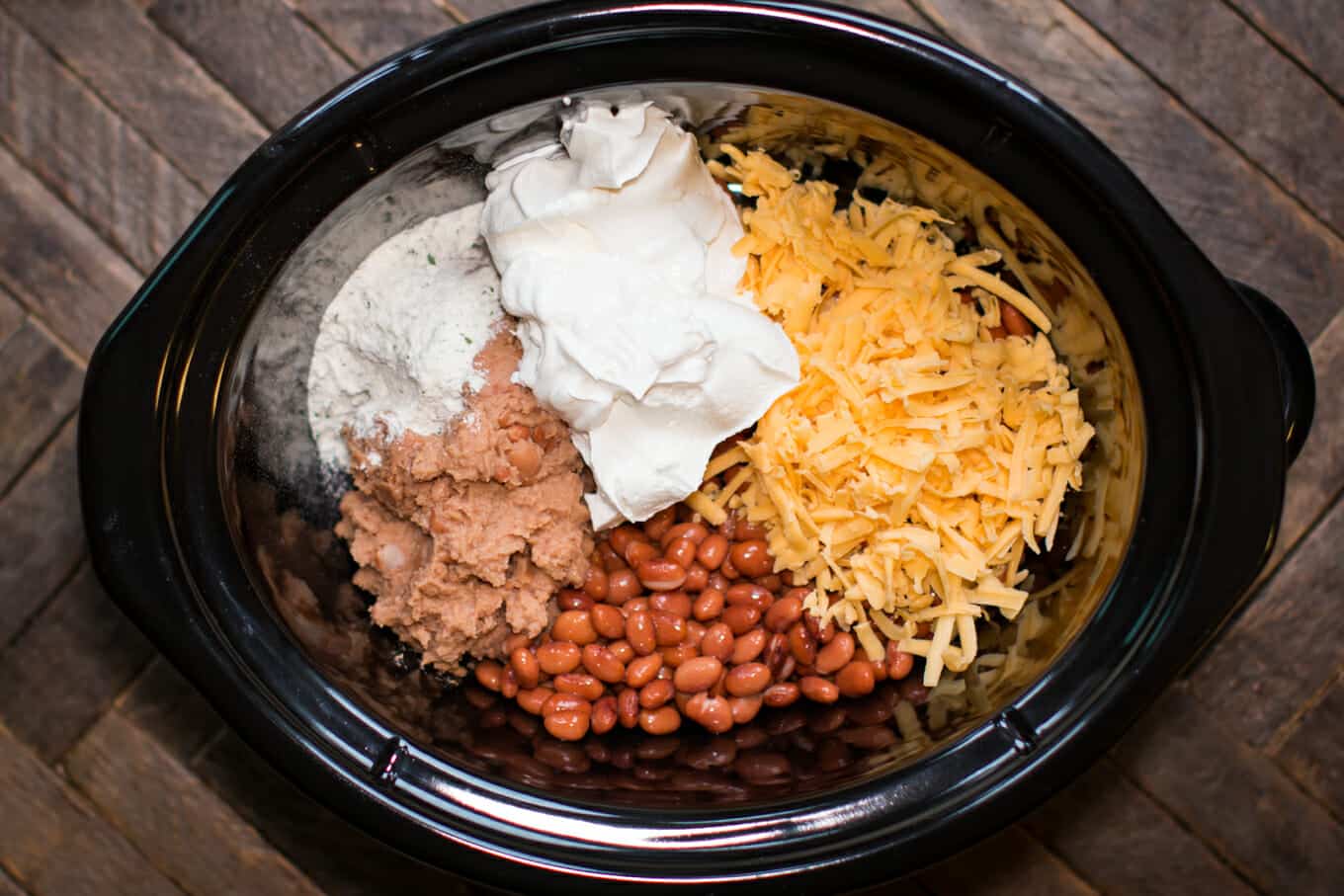 pinto beans, refried beans, sour cream, ranch and cheese in a slow cooker