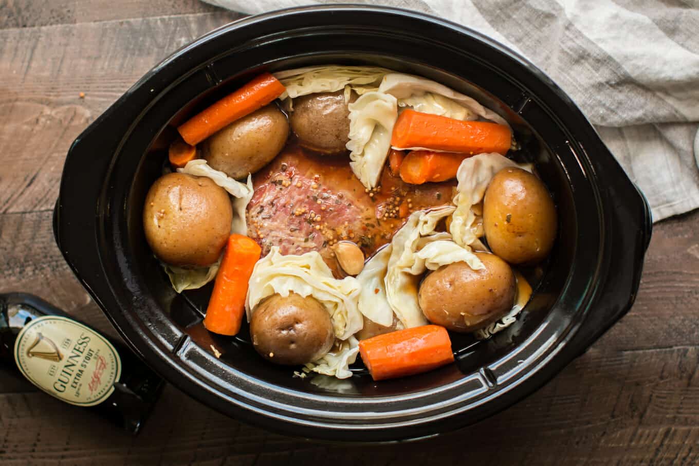 corned beef in slow cooker with potatoes, carrots and cabbage, done cooking.