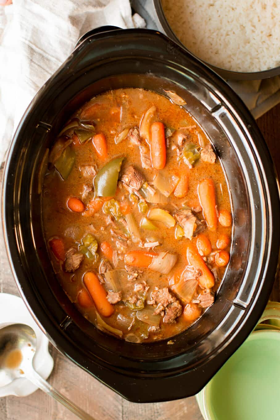 cooked beef stew in slow cooker with carrots and bell pepper