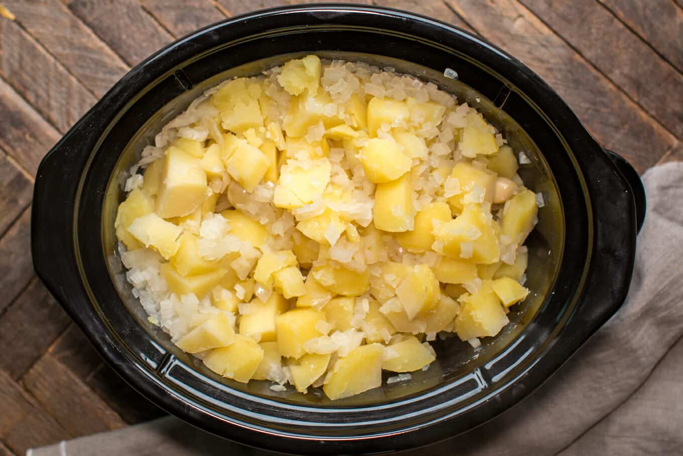 cooked potato cubes and onion in slow cooker