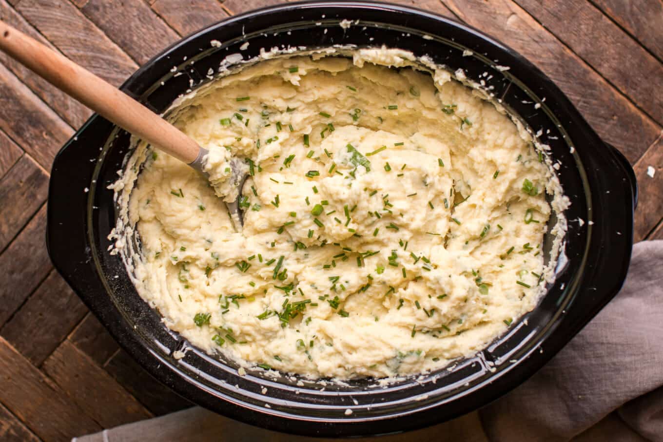 finished cooking sour cream and onion mashed potatoes with wooden spoon in it.