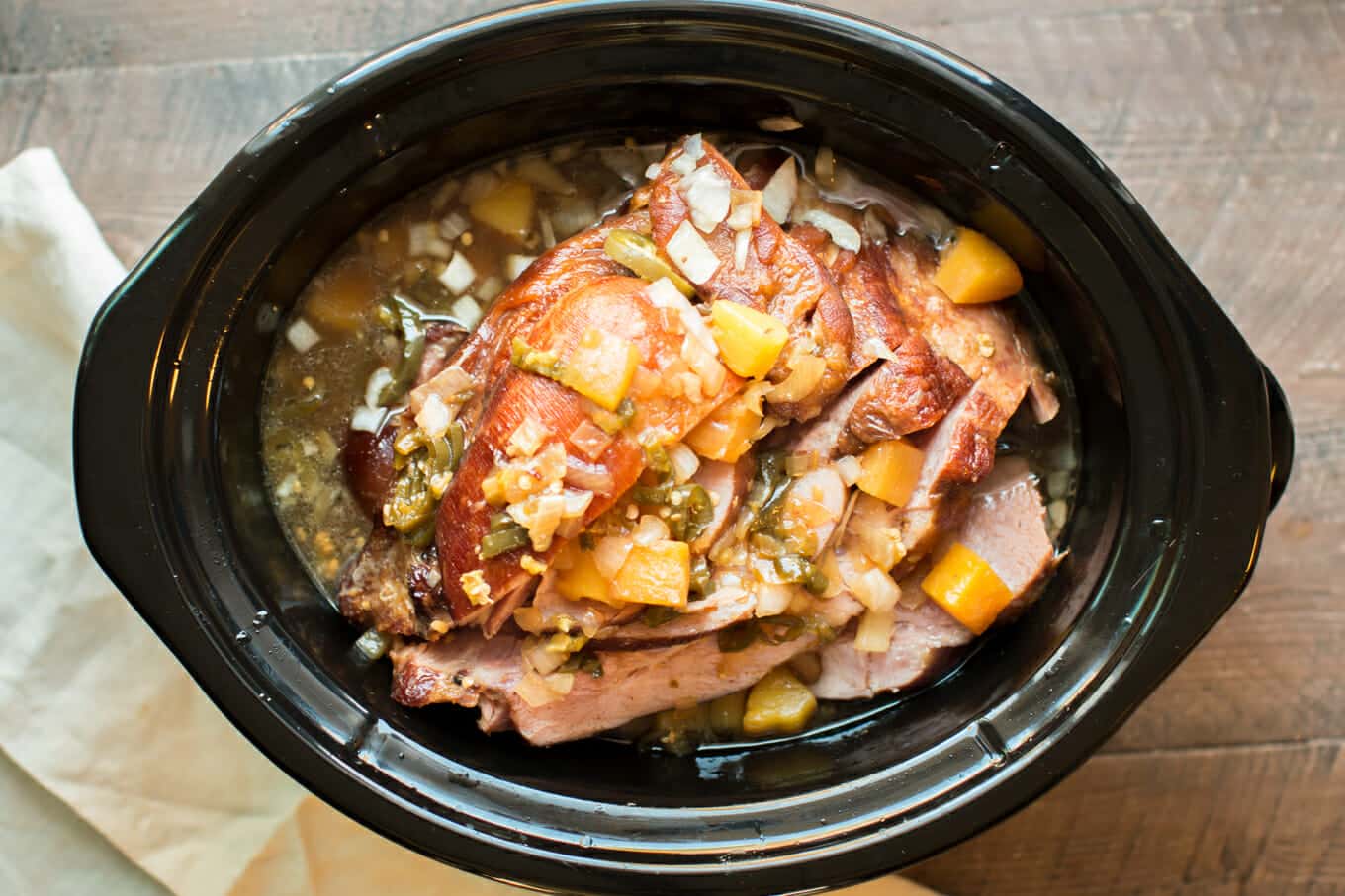 Finished slow cooker pineapple jalapeno ham in slow cooker.