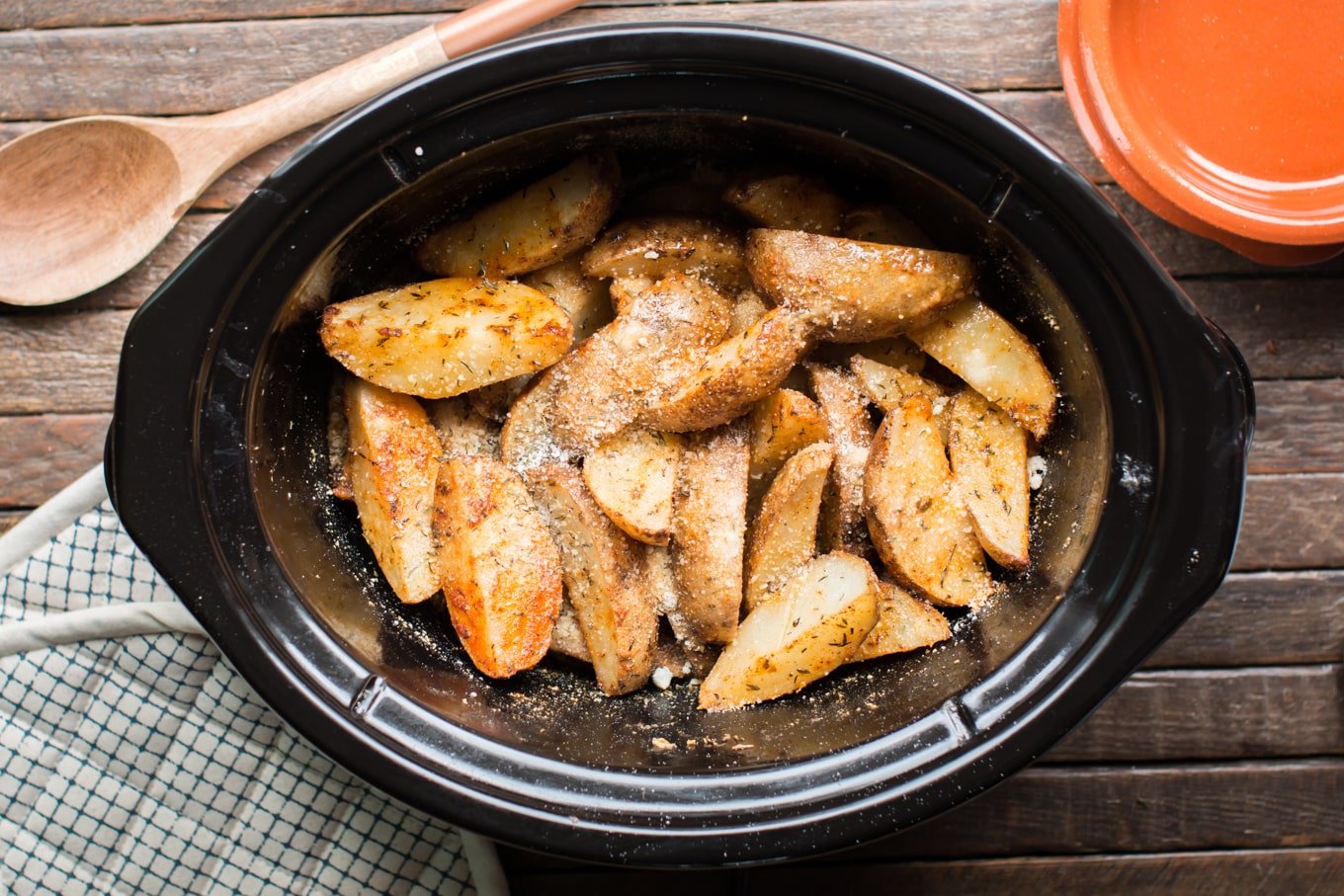 Potato wedges in slow cooker cooked with Parmesan cheese and Cajun spices.