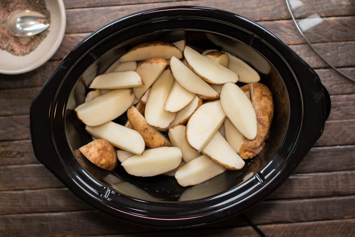 Cut russet potatoes in slow cooker.