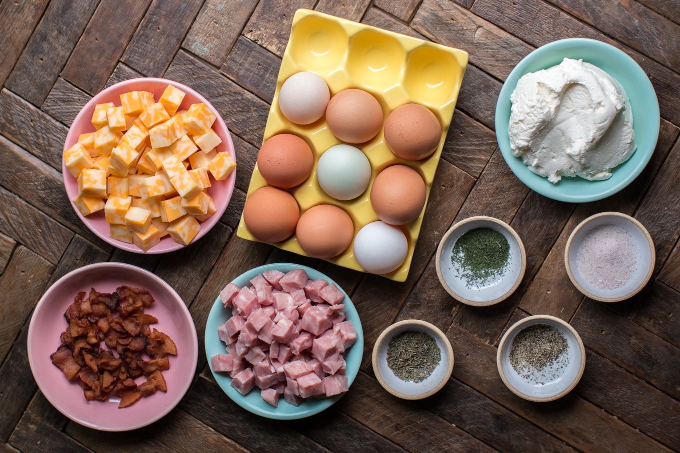 eggs, cheese, ham, bacon, ricotta, seasonings on wooden table