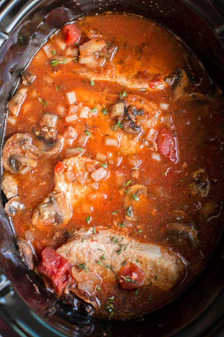 pork chops in slow cooker with tomato mushroom sauce.