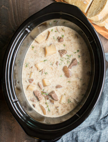 Steak and potato soup in slow cooker with bread on the side.