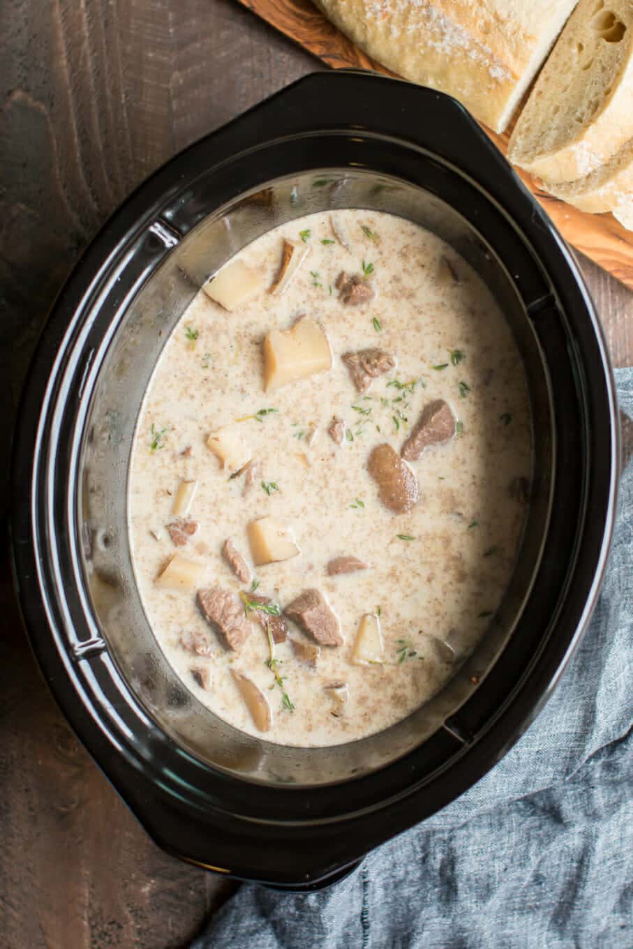 Steak and potato soup in slow cooker with bread on the side.