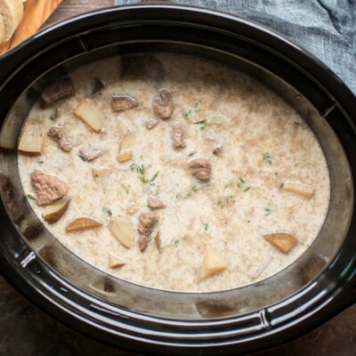 steak and potatoes in creamy broth in slow cooker