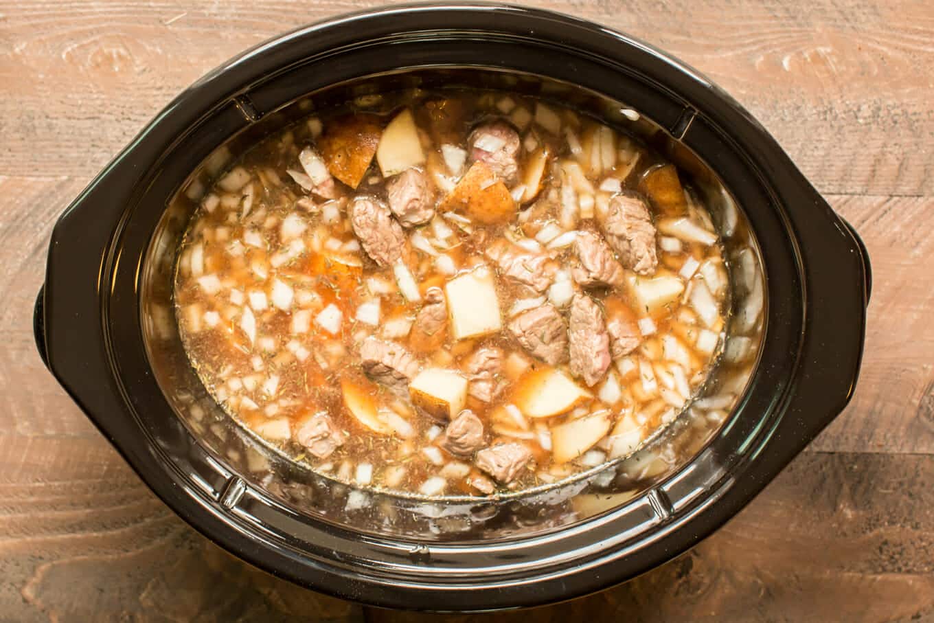 uncooked steak and potato soup in slow cooker