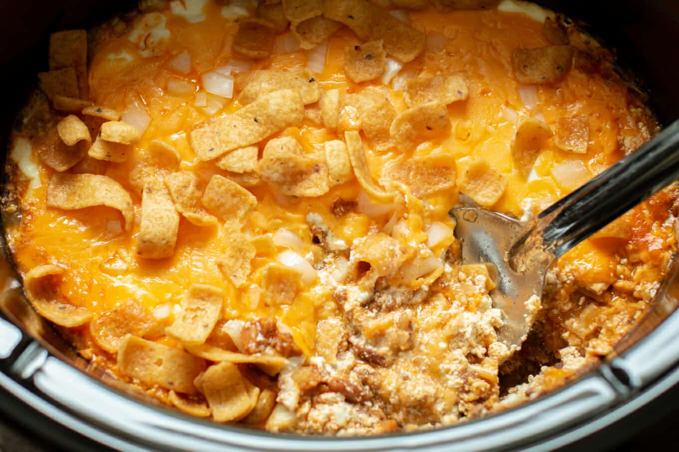 close up of chili cheese casserole with spoon in it.