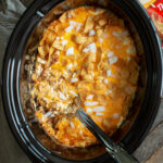 chili cheese casserole with fritos on top in a slow cooker.