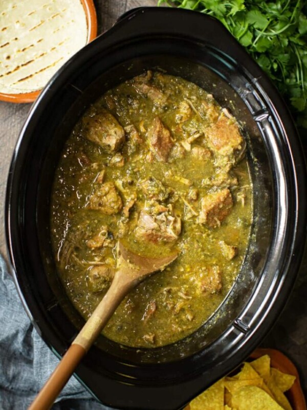 chile verde in slow cooker with spoon.